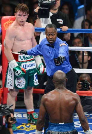 LAS VEGAS, NV - SEPTEMBER 14: Referee Kenny Bayless separates Floyd Mayweather Jr. and Canelo Alvarez in the fourth round of their WBC/WBA 154-pound title fight at the MGM Grand Garden Arena on September 14, 2013 in Las Vegas, Nevada. Mayweather won by majority decision. (Photo by Ethan Miller/Getty Images)