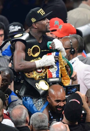 LAS VEGAS, NV - SEPTEMBER 14: CEO of Mayweather Promotions Leonard Ellerbe carries Floyd Mayweather Jr. as he celebrates his majority-decision victory over Canelo Alvarez in their WBC/WBA 154-pound title fight at the MGM Grand Garden Arena on September 14, 2013 in Las Vegas, Nevada. (Photo by Ethan Miller/Getty Images)