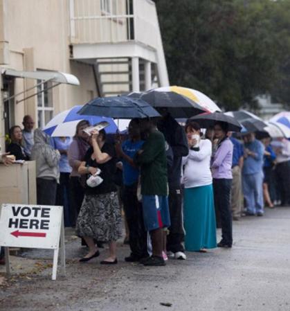 Una fila de votantes espera bajo la lluvia para poder sufragar en St. Petersburg, Florida.