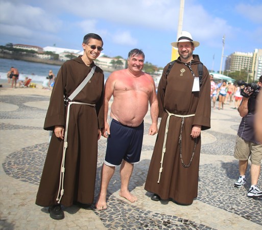Bañista posa con frailes Franciscanos en la Playa de Copacabana