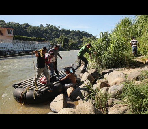 Los inmigrantes utilizan una cuerda para abordar y abandonar la balsa.