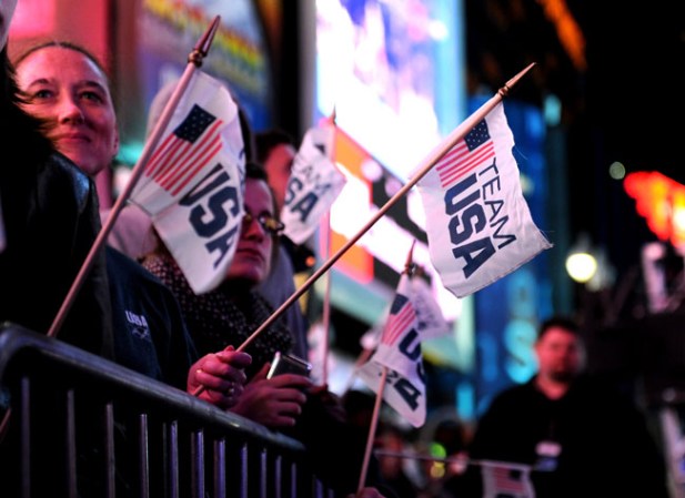 Fanáticos portan banderas para apoyar al equipo de USA durante el evento llevado a cabo en Time Square, NY, para celebrar la cuenta regresiva de 100 días rumbo a los Juegos Olímpicos de Invierno de Sochi 2014.