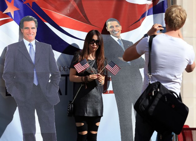 Entusiastas posan con imágenes de los candidatos, el republicano Mitt Romney y el demócrata Barack Obama, previo al debate.