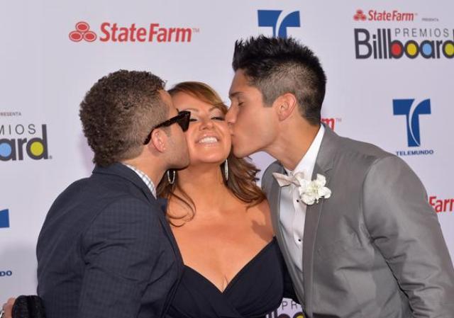 Jenni Rivera recibe dos calurosos besos por parte de Nacho y Chino durante la gala de los Billboard en Miami, 2012.