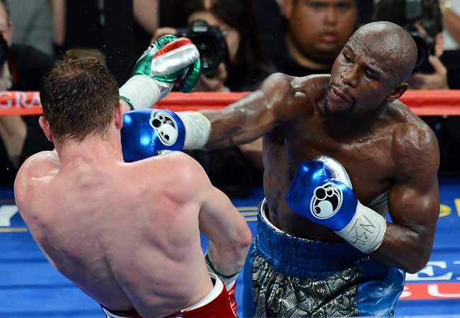 LAS VEGAS, NV - SEPTEMBER 14: Floyd Mayweather Jr. (R) hits Canelo Alvarez in the seventh round of their WBC/WBA 154-pound title fight at the MGM Grand Garden Arena on September 14, 2013 in Las Vegas, Nevada. Mayweather won by majority decision. (Photo by Ethan Miller/Getty Images)