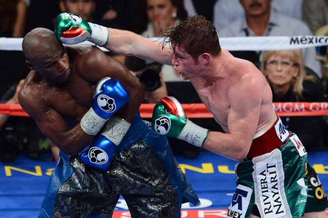 LAS VEGAS, NV - SEPTEMBER 14: (R-L) Canelo Alvarez throws a right at Floyd Mayweather Jr. during their WBC/WBA 154-pound title fight at the MGM Grand Garden Arena on September 14, 2013 in Las Vegas, Nevada. (Photo by Ethan Miller/Getty Images)