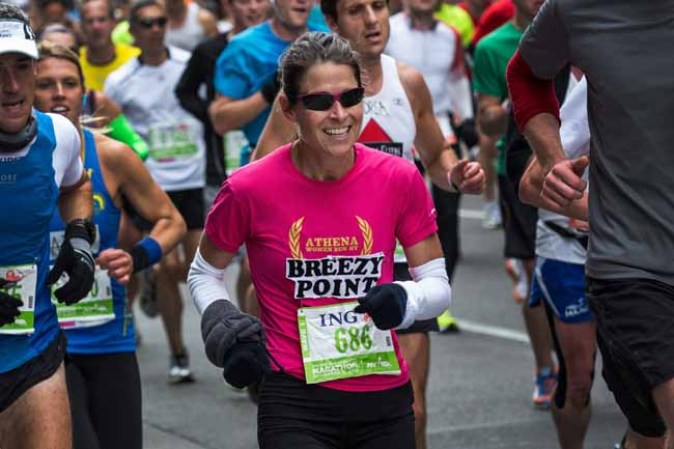 NEW YORK, NY - NOVEMBER 03: A woman wears a "Breezy Point" shirt while running the ING New York City Marathon on November 3, 2013 in the Williamsburg neighborhood of the Brooklyn Borough of New York City. Last year's New York City Marathon was cancelled due to the extensive damage done to the region by Superstorm Sandy - the Breezy Point neighborhood of Queens, NY, was hit especially hard. (Photo by Andrew Burton/Getty Images)
