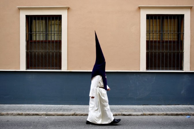 Procesión de la Cofradía de San Gonzálo en Sevilla, España. Los participantes visten los gorros y las túnicas en representación de los nazarenos.