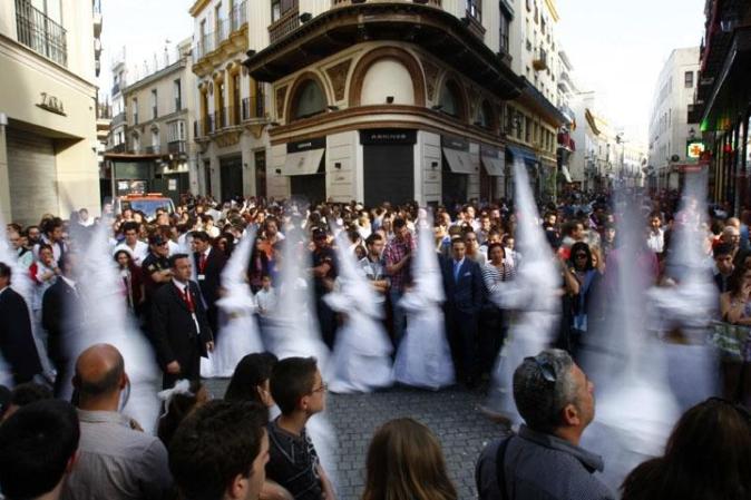 Procesión de la Cofradía de San Gonzálo en Sevilla, España. Los participantes visten los gorros y las túnicas en representación de los nazarenos.
