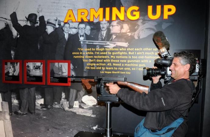 El camarógrafo Richard Gacovino se divierte con una de las metralletas en exhibición.