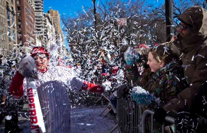 NEW YORK, NY - NOVEMBER 28: Spectators throw confetti during the Macy's Thanksgiving Day Parade on November 28, 2013 in New York City. Despite earlier concerns about the wind, the balloons flew as planned for the parade. (Photo by Kena Betancur/Getty Images)