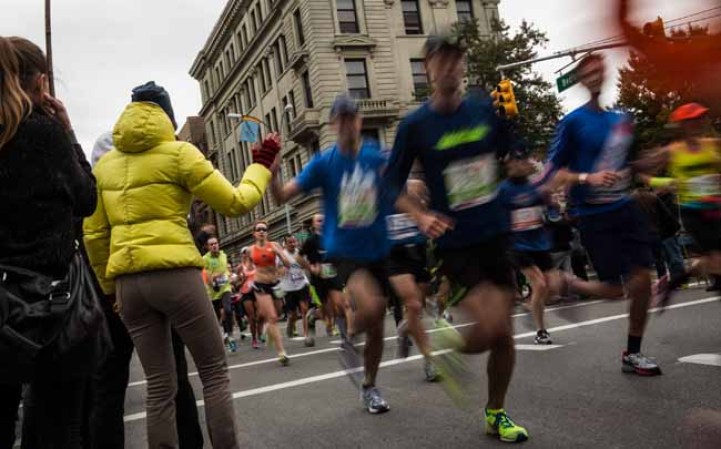 NEW YORK, NY - NOVEMBER 03: A woman offers high-fives to runners running the ING New York City Marathon on November 3, 2013 in the Williamsburg neighborhood of the Brooklyn Borough of New York City. With the Boston Marathon bombing from earlier this year still fresh in many minds, security is especially high this year at the New York City marathon. (Photo by Andrew Burton/Getty Images)
