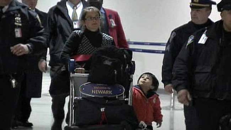 Lori Berenson es escoltada tras su llegada a Nueva York junto a su hijo Salvador Apari en Diciembre 20, 2011.