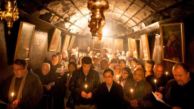 Un grupo de cristianos eleva rezos en la Iglesia de la Natividad, en la antigua ciudad de Belén.