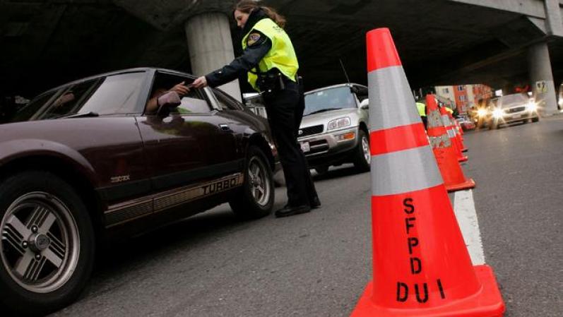 Un agente de policía chequea una Licencia de Manejar durante un control policial en San Francisco, California.