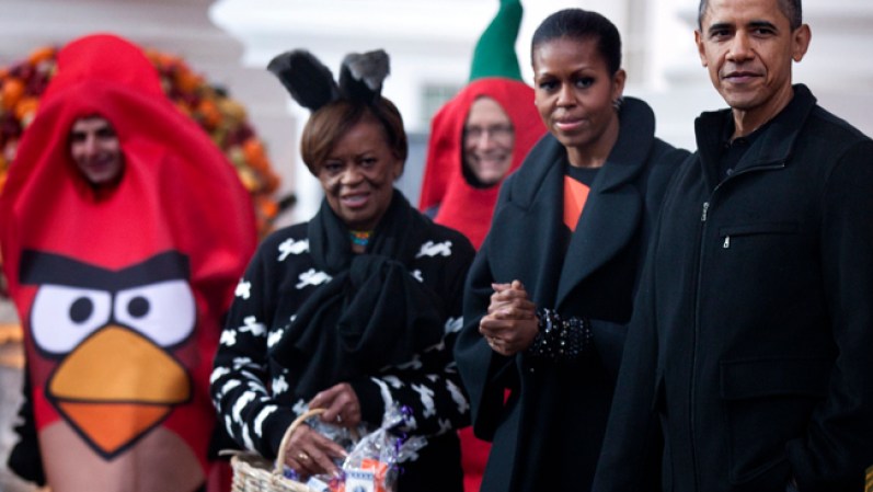 El Presidente Barack Obama, la Primera Dama y su madre, Marian Robinson, saludan a los niños disfrazados en la Casa Blanca, el 29 de octubre de 2011.