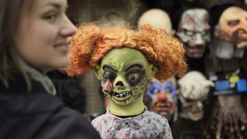 Una cliente sonríe ante una aterradora máscara en la tienda Fantasy Costumes de Chicago, Illinois.