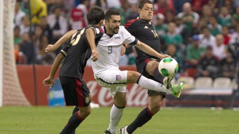 Javier Hernandez (#14), del equipo de México, lucha por la pelota coh Hercules Gomez (#9), de Estados Unidos.