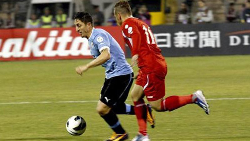 El jugador jordano Oday Zahran lucha por el control del balón ante el uruguayo Cristian Rodríguez.