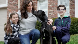 The Simeon family poses with Nala, a dog they are fostering