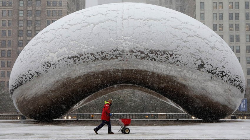 A maintenance worker spreads salt in the area around Cloud Gate during a morning rush hour snow storm as a winter weather advisory is issued for the Chicago area on Monday, Nov. 11, 2019. (Antonio Perez/ Chicago Tribune/Tribune News Service via Getty Images)