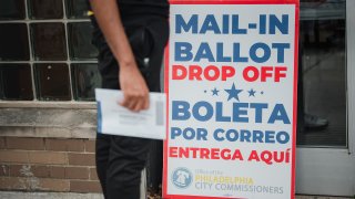 A voter waits to drop off a mail-in ballot.