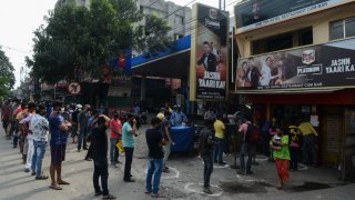 Clientes esperan fuera de una licorería en Siliguri, India, el lunes.