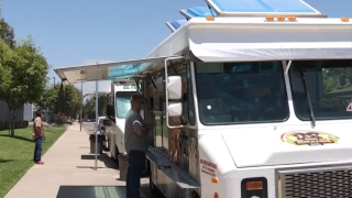 man stands at the window of a white food truck