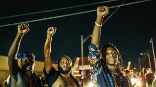 Protesters raise their fists during a demonstration against the shooting of Jacob Blake in Kenosha