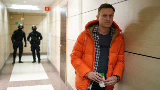 Russian opposition leader Alexei Navalny stands near law enforcement agents in a hallway of a business centre, which houses the office of his Anti-Corruption Foundation (FBK), in Moscow on December 26, 2019