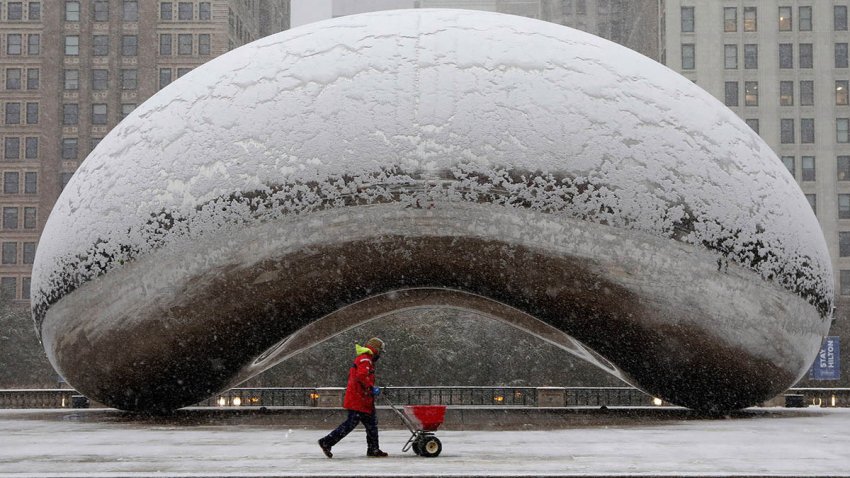 A maintenance worker spreads salt in the area around Cloud Gate during a morning rush hour snow storm as a winter weather advisory is issued for the Chicago area on Monday, Nov. 11, 2019. (Antonio Perez/ Chicago Tribune/Tribune News Service via Getty Images)