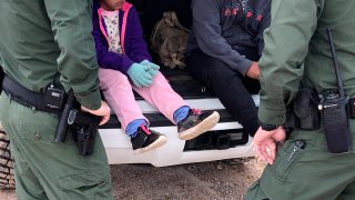 Fotografía de archivo donde aparecen dos agentes de la Patrulla Fronteriza mientras atienden a unos niños en un punto del área conocido como Quitobaquito, en la frontera de Arizona con México (EEUU).