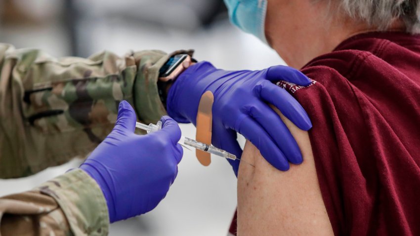 A woman receives a Pfizer Covid-19 vaccine at a vaccination center established at the Triton College in River Grove, Illinois