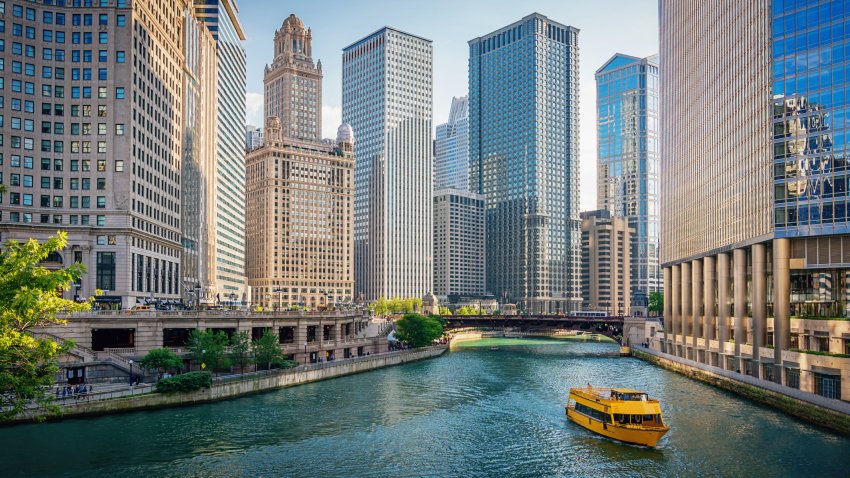 Downtown Chicago Skyscraper Cityscape along the Chicago River. Typical yellow Tourboat cruising on the Chicago River towards the Michigan Lake. Chicago, Illinois, USA.