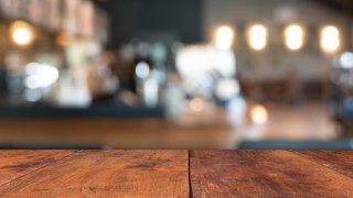 A empty wooden table in front of a blurred background