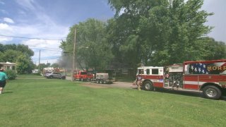 Several fire trucks are seen as smoke billows from an industrial building that caught fire Tuesday in Morris, Illinois.