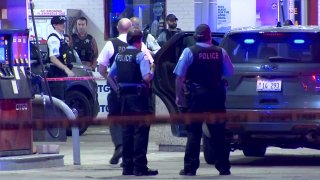 Chicago police officers stand near a squad SUV after a shooting near a Citgo gas station on October 20, 2021.