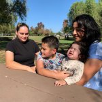 Dos madres con sus hijos en un mesa de un parque