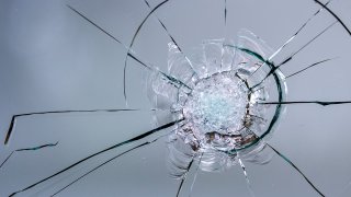 Foto de archivo de un impacto de bala en un cristal.