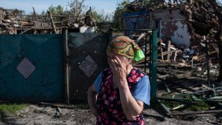 Una mujer llora frente a su casa destruida por un misil ruso, en Pidhaine, Ucrania.