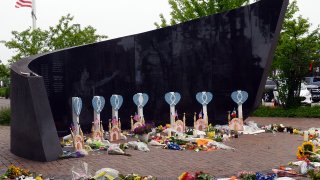 People lay flowers and cards near a spot where a mass shooting took place during the 4th of July parade in Highland Park, Illinois on July 6, 2022.