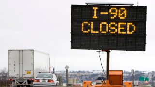 Traffic travels past a reader board indicating the closure of Interstate 90 at the Montana-Wyoming border