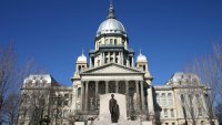 Illinois State Capitol Building with Abraham Lincoln statue and a clear blue sky.