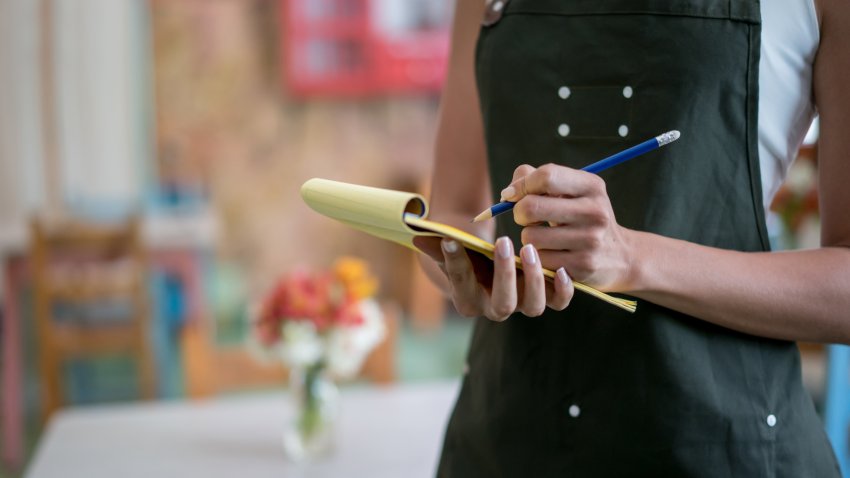 Waitress taking an order at a restaurant. Close-up on a notepad