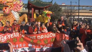 Foto de varias personas aguantando una pancarta que dice 2024 Year of the Dragon.