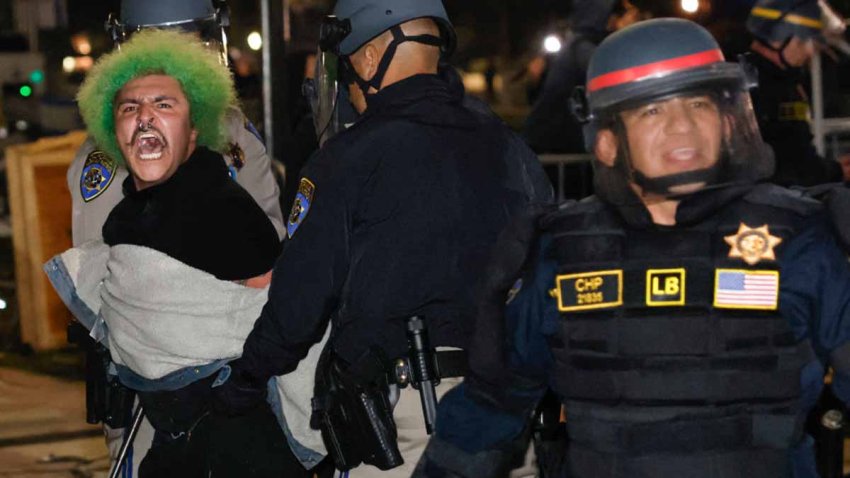 Police make an arrest as they face-off with pro-Palestinian students after destroying part of the encampment barricade on the campus of the University of California, Los Angeles (UCLA) in Los Angeles, California, early on May 2, 2024. Police deployed a heavy presence on US university campuses on May 1 after forcibly clearing away some weeks-long protests against Israel’s war with Hamas. Dozens of police cars patrolled at the University of California, Los Angeles campus in response to violent clashes overnight when counter-protesters attacked an encampment of pro-Palestinian students. (Photo by Etienne LAURENT / AFP) (Photo by ETIENNE LAURENT/AFP via Getty Images)