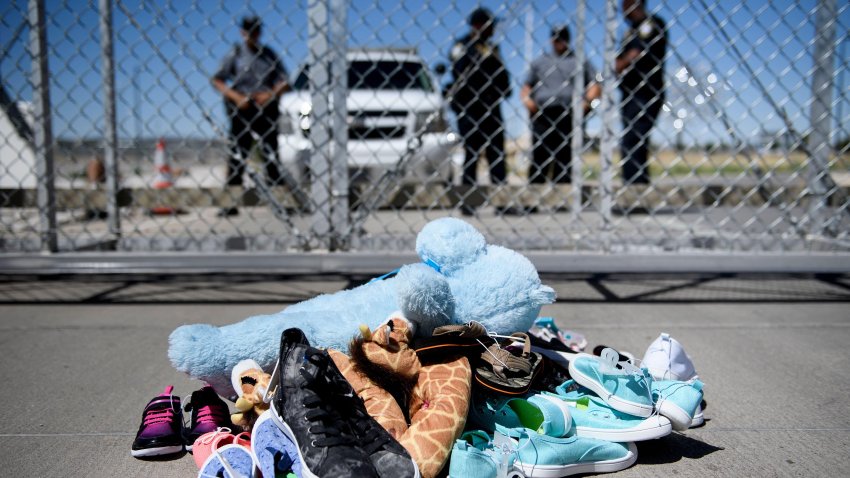 TOPSHOT – Security personal stand before shoes and toys left at the Tornillo Port of Entry where minors crossing the border without proper papers have been housed after being separated from adults, June 21, 2018 in Tornillo, Texas. – President Donald Trump ordered an end to the separation of migrant children from their parents on the US border June 20, 2018, reversing a tough policy under heavy pressure from his fellow Republicans, Democrats and the international community. The spectacular about-face comes after more than 2,300 children were stripped from their parents and adult relatives after illegally crossing the border since May 5 and placed in tent camps and other facilities, with no way to contact their relatives. (Photo by Brendan Smialowski / AFP) (Photo by BRENDAN SMIALOWSKI/AFP via Getty Images)