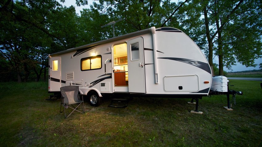 Modern 25 Feet Travel Trailer – Camping in the Forest. Evening/Dusk Photography. Recreation Photo Collection