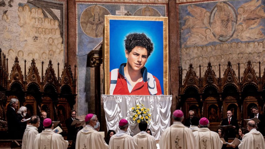 ASSISI, ITALY – OCTOBER 10: A tapestry  featuring a portrait of Carlo Acutis is hang at the St. Francis Basilica during the beatification ceremony of Carlo Acutis, on October 10, 2020 in Assisi, Italy. The fifteen-year-old Carlo Acutis member of the Millennial generation who died on 12 October 2006 from M3 fulminant leukemia, is considered a “computer geek” on account of his passion and skill with computers and the internet. Acutis applied himself to creating a website dedicated to cataloguing each reported Eucharistic miracle in the world. (Photo by Vatican Pool/Getty Images)