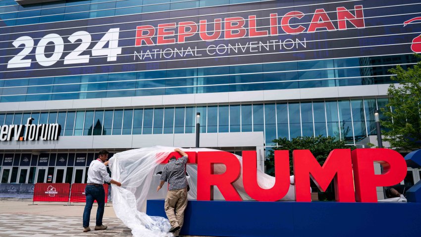 Workers remove plastic covering from signage ahead of the Republican National Convention (RNC) in Milwaukee, Wisconsin, US, on Sunday, July 14, 2024. Former President Donald Trump confirmed that he will be attending the Republican National Convention next week, hours after he was shot at a campaign rally in Pennsylvania. Photographer: Al Drago/Bloomberg via Getty Images